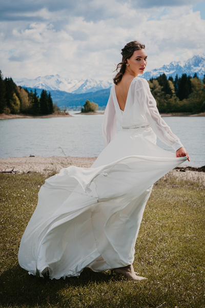 Die Braut in weißem fließenden Kleid auf der Bergsee-Hochzeit